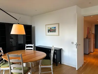 a dining room with a wooden table and chairs at Executive Quartermile apartment near to Castle University with park view in Edinburgh