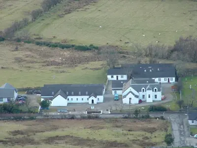 a group of houses on a hill in a field at Lochranza Centre CIC in Lochranza