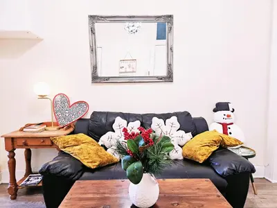 a living room with a black couch with pillows at No15 Castle View in Edinburgh