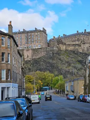 a street with cars parked in front of a castle at No15 Castle View in Edinburgh