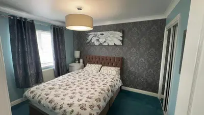a bedroom with a bed and a picture on the wall at Glasgow Central guest house free parking in Govan