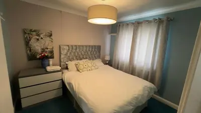 a small bedroom with a bed and a lamp at Glasgow Central guest house free parking in Govan