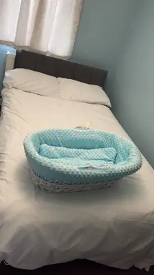 a bed with a blue blanket and a basket on it at Glasgow Central guest house free parking in Govan