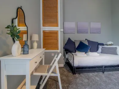 a bedroom with a bed with blue pillows and a desk at Spacious Hillhead Haven - Pass the Keys in Glasgow