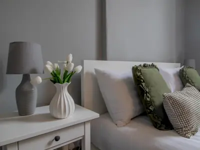 a white couch with pillows and a table with a lamp at Spacious Hillhead Haven - Pass the Keys in Glasgow