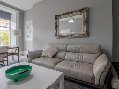 a living room with a couch and a mirror at Spacious Hillhead Haven - Pass the Keys in Glasgow