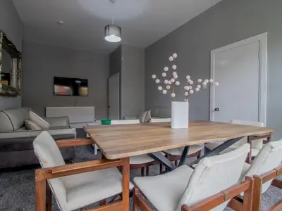 a living room with a wooden table and chairs at Spacious Hillhead Haven - Pass the Keys in Glasgow