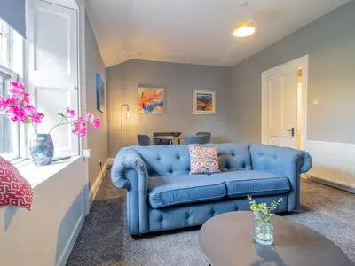 a living room with a blue couch and a table at The Blue Nile Hillhead - Pass the Keys in Glasgow