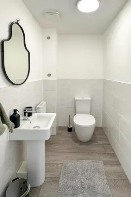 a white bathroom with a toilet and a sink at Newbuild Riverview 3BDR House near Glasgow in Dalmuir