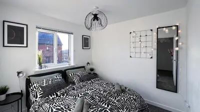 a bedroom with a bed with black and white pillows at Newbuild Riverview 3BDR House near Glasgow in Dalmuir