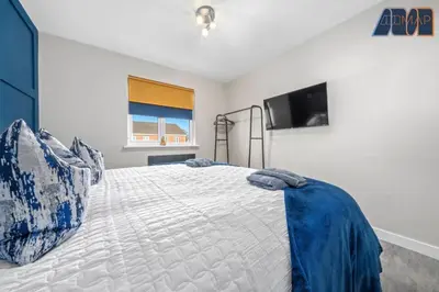 a bedroom with a bed and a television in it at Elegant 2Bed Sleeps 4 With Parking in Paisley