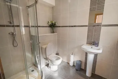 a bathroom with a toilet and a sink and a shower at Stunning Sea Views - Luxury 4BR Beach House in Oban