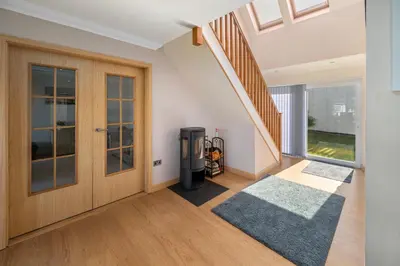 a hallway with a staircase and a door and a rug at Stunning Sea Views - Luxury 4BR Beach House in Oban