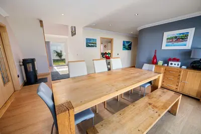 a dining room with a wooden table and chairs at Stunning Sea Views - Luxury 4BR Beach House in Oban