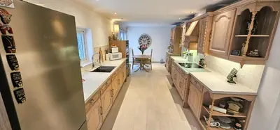 a large kitchen with wooden cabinets and a stainless steel refrigerator at Boghead Cottage The West Wing in Bathgate