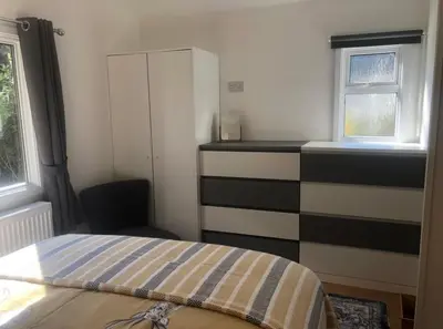 a bedroom with a bed and a dresser and a window at The Art Studio Arran in Isle of Arran