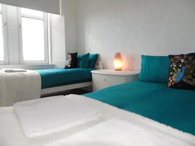 a living room with two beds and a couch at Snug - Grian-aig Apartment in Greenock