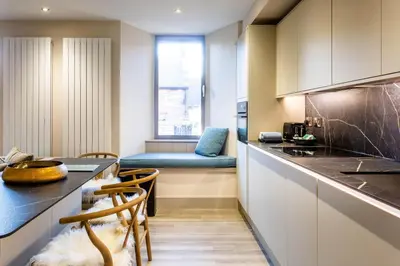 a kitchen with a counter and a table and chairs at Arran Shores Luxury Shorefront Apartment 2 in Lamlash