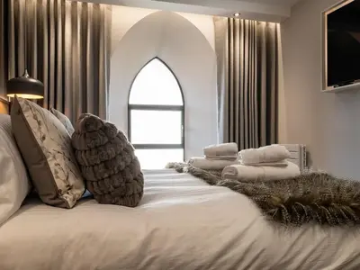 a bedroom with a large bed with a large window at Arran Shores Luxury Shorefront Apartment 3 in Lamlash