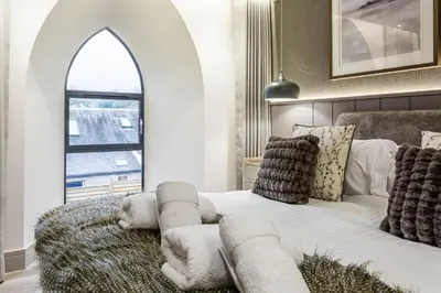 a bedroom with a white bed with a large window at Arran Shores Luxury Shorefront Apartment 4 in Lamlash