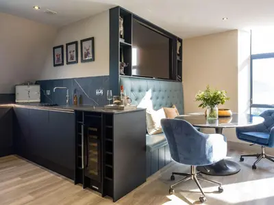 a kitchen with a counter and a table and chairs at Arran Shores Luxury Shorefront Penthouse Suite 12 in Lamlash