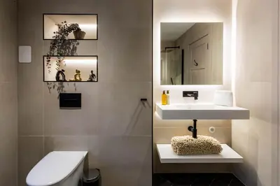 a bathroom with a sink and a toilet and a mirror at Arran Shores Luxury Shorefront Penthouse Suite 12 in Lamlash