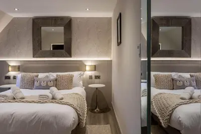 two beds in a room with two mirrors at Arran Shores Luxury Shorefront Penthouse Suite 12 in Lamlash