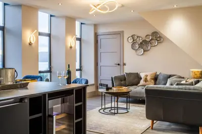 a living room with a couch and a table at Arran Shores Luxury Shorefront Penthouse Suite 12 in Lamlash