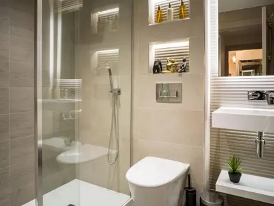 a bathroom with a shower and a toilet and a sink at Arran Shores Luxury Shorefront Apartment 5 in Lamlash