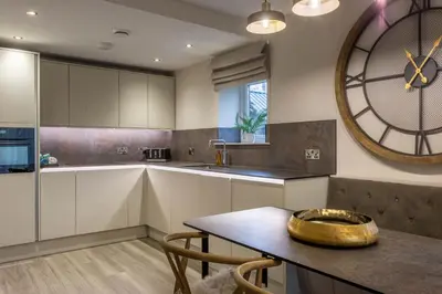 a kitchen with a large clock on the wall at Arran Shores Luxury Shorefront Garden Terrace Apartment 6 in Lamlash