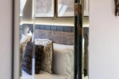 a bed in a room with pillows on it at Arran Shores Luxury Shorefront Apartment 14 in Lamlash