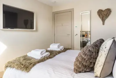 a bedroom with a bed with towels on it at Arran Shores Luxury Shorefront Apartment 14 in Lamlash