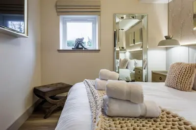 a bedroom with a bed with towels on it at Arran Shores Luxury Shorefront Garden Terrace Apartment 7 in Lamlash