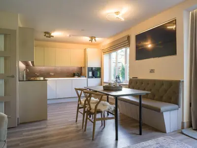 a kitchen and dining room with a table and chairs at Arran Shores Luxury Shorefront Garden Terrace Apartment 7 in Lamlash
