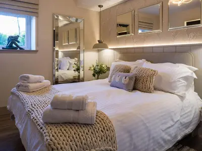 a bedroom with a large bed with towels on it at Arran Shores Luxury Shorefront Garden Terrace Apartment 7 in Lamlash