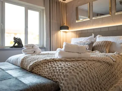 a bedroom with a large bed with towels on it at Arran Shores Luxury Shorefront Apartment 8 in Lamlash