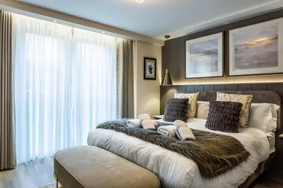 a bedroom with a large bed with a large window at Arran Shores Luxury Shorefront Apartment 9 in Lamlash