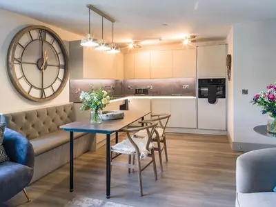 a kitchen and living room with a table and chairs at Arran Shores Luxury Shorefront Apartment 9 in Lamlash