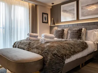a bedroom with a large bed with a large window at Arran Shores Luxury Shorefront Apartment 9 in Lamlash