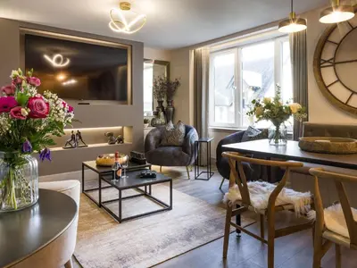 a living room with a table and chairs and a living room with a couch at Arran Shores Luxury Shorefront Apartment 9 in Lamlash