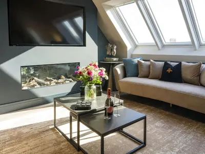 a living room with a couch and a fireplace at Arran Shores Luxury Shorefront Penthouse Suite 11 in Lamlash