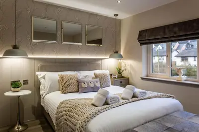 a bedroom with a bed with pillows and a window at Arran Shores Luxury Shorefront Penthouse Suite 11 in Lamlash
