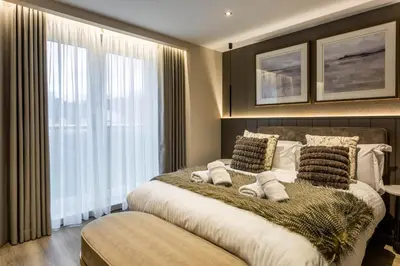 a bedroom with a large bed and a window at Arran Shores Luxury Shorefront Penthouse Suite 11 in Lamlash