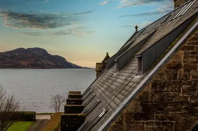 an old building with a view of the water at Arran Shores Luxury Shorefront Penthouse Suite 11 in Lamlash