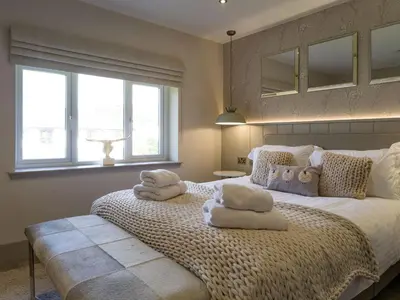 a bedroom with a large bed with towels on it at Arran Shores Luxury Shorefront Penthouse Suite 10 in Lamlash