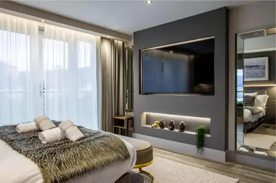a bedroom with a large mirror and a tv at Arran Shores Luxury Shorefront Penthouse Suite 10 in Lamlash