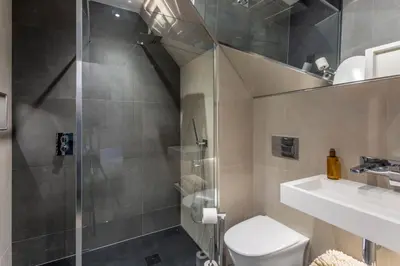 a bathroom with a shower and a toilet and a sink at Arran Shores Luxury Shorefront Penthouse Suite 13 in Lamlash