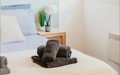 a stuffed teddy bear sitting on top of a bed at Glasgow City Centre Apartment in Glasgow