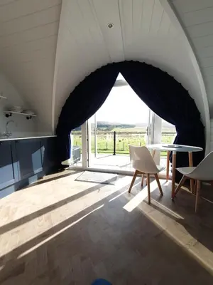 a room with a large window and a table and chairs at East Rigg Lodges in Balerno