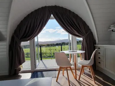 a kitchen with a table and chairs in front of a window at East Rigg Lodges in Balerno